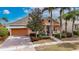 Orange house with a two-car garage and lush landscaping at 5253 Brighton Shore Dr, Apollo Beach, FL 33572