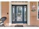 Inviting front entrance with a decorative glass door and wicker chair at 5253 Brighton Shore Dr, Apollo Beach, FL 33572