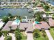 Aerial view showcasing a waterfront property with a private dock and pool at 725 Capri Blvd, Treasure Island, FL 33706