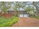 Mid-century modern home with lush landscaping and a two-car garage at 751 Pinellas Point S Dr, St Petersburg, FL 33705