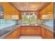 Retro kitchen with wood cabinets, light blue tile, and a double sink at 751 Pinellas Point S Dr, St Petersburg, FL 33705