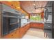Kitchen with wood cabinets, black appliances, and retro style at 751 Pinellas Point S Dr, St Petersburg, FL 33705