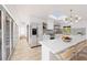 Bright kitchen with stainless steel appliances, a large island with marble countertop, and open access to the outdoor patio at 751 Pinellas Point S Dr, St Petersburg, FL 33705