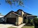 Two-story house with brown garage door and landscaping at 8103 Tar Hollow Dr, Gibsonton, FL 33534