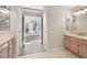 Bathroom with double vanity and view to living area at 9116 Exposition Dr, Tampa, FL 33626