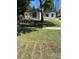 White house with a detached shed and grassy yard at 8465 N Tobay Rd, St Petersburg, FL 33702