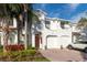 White townhouse with red tile roof, two-car garage, and landscaping at 10308 Saville Rowe Ln, Tampa, FL 33626