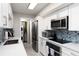 Modern kitchen with white cabinets and stainless steel appliances at 10355 Paradise Blvd # 207, Treasure Island, FL 33706