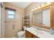 Bright bathroom with a framed mirror, window, and toilet at 10704 Mira Vista Dr, Port Richey, FL 34668