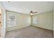 Spacious bedroom with natural light, carpet and ceiling fan, providing a comfortable and relaxing atmosphere at 10704 Mira Vista Dr, Port Richey, FL 34668