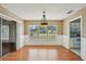 Dining area with chandelier, sliding glass doors and adjacent kitchen, ideal for Gathering meals and entertaining at 10704 Mira Vista Dr, Port Richey, FL 34668