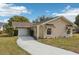 Tan single-story house with a garage and landscaped yard at 10704 Mira Vista Dr, Port Richey, FL 34668