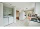 Bright kitchen featuring white appliances, tile flooring, laundry area and ample storage space, functional design at 10704 Mira Vista Dr, Port Richey, FL 34668