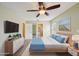 Staged main bedroom with an ensuite bathroom, decorated with a dresser and a serene beach painting at 10704 Mira Vista Dr, Port Richey, FL 34668