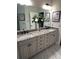 Double vanity bathroom with granite countertops and large mirror at 10880 Cory Lake Dr, Tampa, FL 33647
