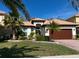 Single-story home with tile roof, large garage, and landscaped lawn at 10880 Cory Lake Dr, Tampa, FL 33647