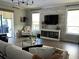 Bright living room features a stone accent wall, comfortable seating, and a large TV at 10880 Cory Lake Dr, Tampa, FL 33647