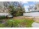 Backyard with a grassy area, stone wall, and a white fence at 136 26Th Ne Ave, St Petersburg, FL 33704