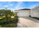 Two-car garage with a driveway and landscaping at 13607 Circa Crossing Dr, Lithia, FL 33547