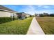 Sidewalk next to homes with lush landscaping and a view of a grassy field at 13607 Circa Crossing Dr, Lithia, FL 33547