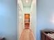 Light and airy bathroom hallway with light wood floors and access to multiple rooms at 13653 Heritage Way, Sarasota, FL 34240