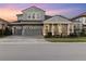 Two-story home with gray siding, three-car garage, and landscaping at 14215 Swiss Bridge Dr, Riverview, FL 33579