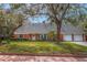 Charming brick house with a two-car garage, lush lawn, and mature landscaping creating curb appeal at 1610 Serpentine S Dr, St Petersburg, FL 33712