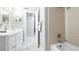 Bright bathroom features a single vanity with white cabinets, tiled shower, and neutral walls and floors at 1712 Blind Pond Ave, Lutz, FL 33549