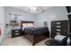 Bedroom featuring a dark brown bed, tile floors, a side table, and a dresser at 1712 Blind Pond Ave, Lutz, FL 33549