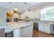Gourmet kitchen with white cabinets, granite island, and stainless steel appliances at 1840 Douglas Ave, Dunedin, FL 34698