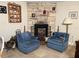 Cozy living room with stone fireplace, plush blue armchairs, and decorative accents at 1880 Belleair Rd, Clearwater, FL 33764