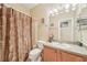 Clean bathroom with a shower/tub combo and wood vanity at 21042 Diamonte Dr, Land O Lakes, FL 34637
