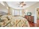 Bright bedroom featuring hardwood floors, a king-size bed, and plantation shutters at 21042 Diamonte Dr, Land O Lakes, FL 34637