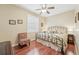 Comfortable bedroom with hardwood floors, a ceiling fan, and a sitting chair at 21042 Diamonte Dr, Land O Lakes, FL 34637