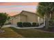 Well-maintained home exterior at sunset, featuring a garage and landscaped yard at 21042 Diamonte Dr, Land O Lakes, FL 34637