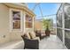 Cozy screened porch with seating for two at 21042 Diamonte Dr, Land O Lakes, FL 34637