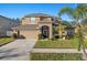 Two-story house with tan exterior, two-car garage, and landscaped lawn at 2307 Dakota Rock Dr, Ruskin, FL 33570
