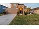 Two-story house with tan exterior, two-car garage, and landscaped lawn at 2307 Dakota Rock Dr, Ruskin, FL 33570