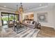 Spacious living room with large windows, comfortable seating, and a view of the pool at 2471 Overfalls Pl, Wesley Chapel, FL 33543