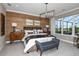 Spacious main bedroom with wood accent wall, large windows, and comfortable seating at 2471 Overfalls Pl, Wesley Chapel, FL 33543