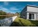 Gray house with a pond view, white fence, and grassy backyard at 26932 Sea Breeze Way, Wesley Chapel, FL 33544
