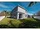 Gray house with a large backyard and pond view at 26932 Sea Breeze Way, Wesley Chapel, FL 33544