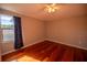 Spacious bedroom featuring hardwood floors and a window with curtains at 26932 Sea Breeze Way, Wesley Chapel, FL 33544