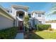 Front view of two-story house with gray siding, manicured landscaping, and a walkway at 26932 Sea Breeze Way, Wesley Chapel, FL 33544