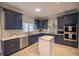 Modern kitchen with dark blue cabinets, quartz countertops, and stainless steel appliances at 26932 Sea Breeze Way, Wesley Chapel, FL 33544