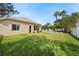 A beautifully landscaped backyard with green lawn, mature trees, and private pool at 2902 Big Cypress Way, Wesley Chapel, FL 33544