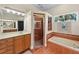 Large bathroom featuring wood cabinets, tile floors, a shower, and a separate tub at 2902 Big Cypress Way, Wesley Chapel, FL 33544