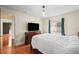 Bedroom with a large TV, hardwood floors, bed and window with blue curtains at 2902 Big Cypress Way, Wesley Chapel, FL 33544