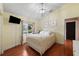 Cozy bedroom featuring a metal frame bed, mounted TV, and a bright window at 2902 Big Cypress Way, Wesley Chapel, FL 33544