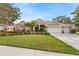 Lovely home with a manicured lawn, mature trees and a three-car garage at 2902 Big Cypress Way, Wesley Chapel, FL 33544